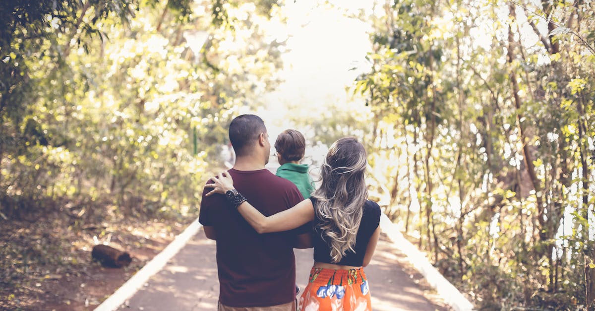 A family enjoying a leisurely walk on a sunny park trail, showcasing togetherness and love.