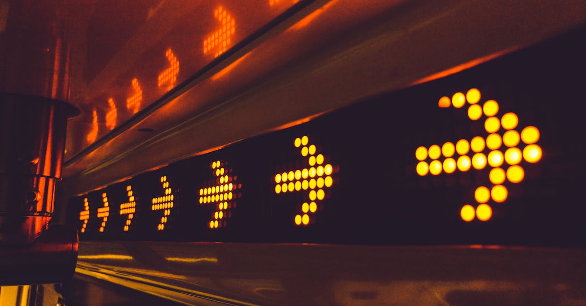 A series of glowing arrow signs in a city environment, indicating direction at night.