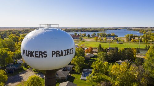 Aerial view of Parkers Prairie watertower with city and lake in the background