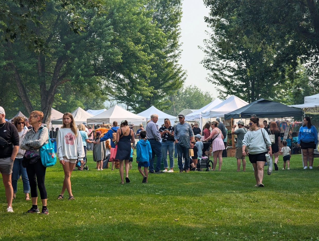 A crowd of people walking through the tents at the Phelps Mill Festival